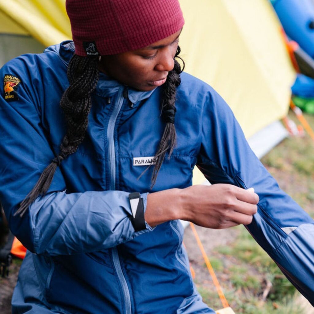 Lady wearing lightweight layers and demonstrating zip on the inside of arm 