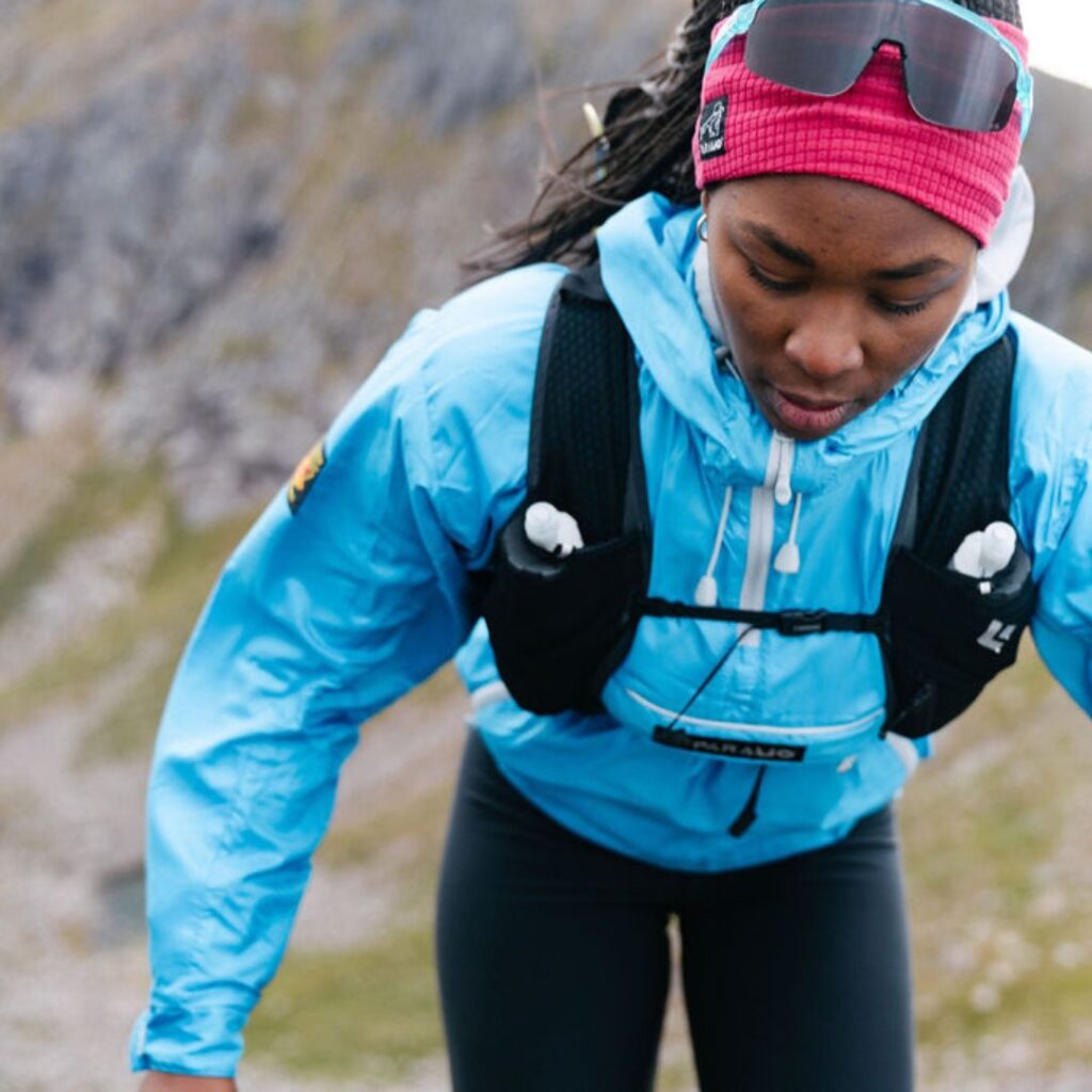 Lady scrambling in the mountains, showing the need for movement in your waterproof jacket 