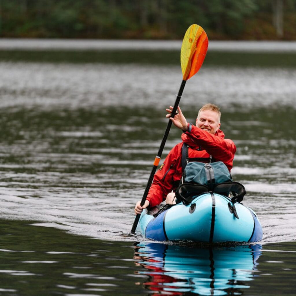 Man kayaking on a lake in a Páramo waterproof jacket 