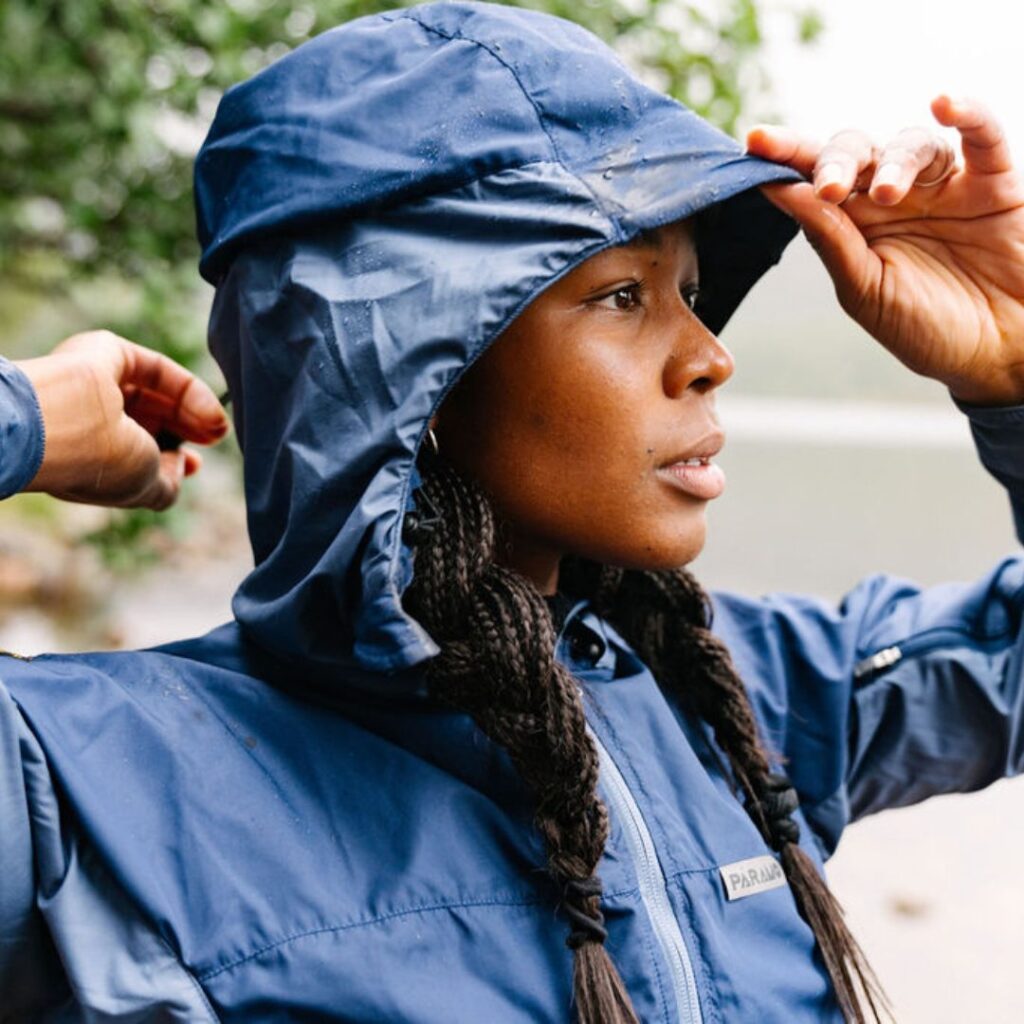 Lady demonstrating the wired and peaked hood of her waterproof jacket 